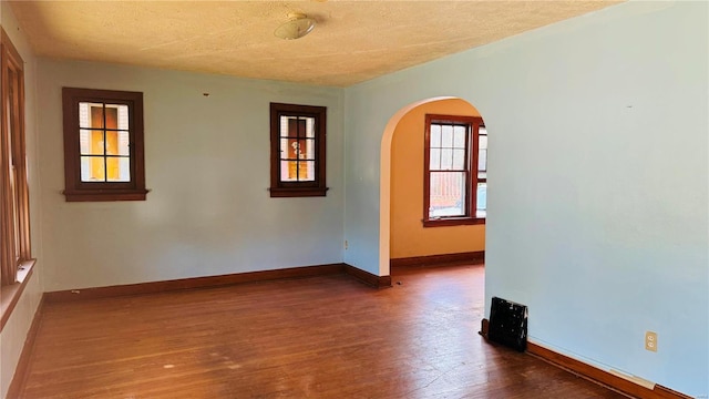 empty room featuring dark wood-type flooring and a textured ceiling