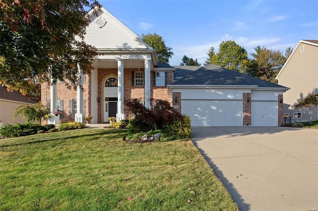 neoclassical / greek revival house featuring a front yard and a garage