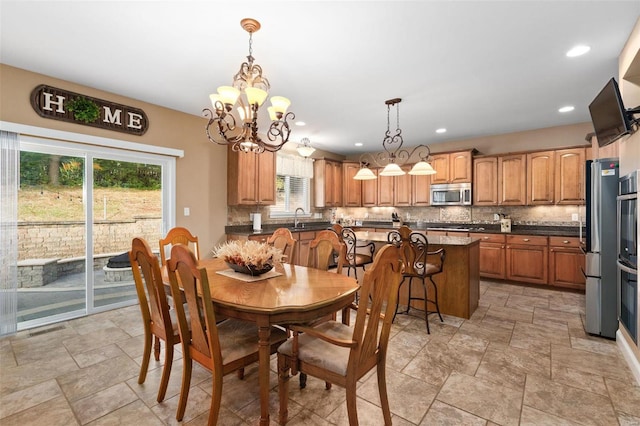 dining room featuring sink, a wealth of natural light, and a chandelier