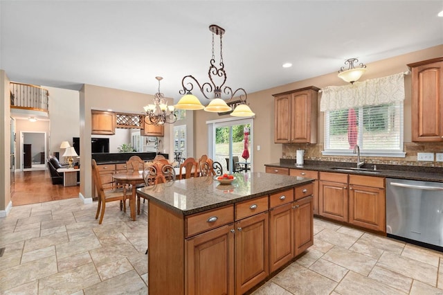 kitchen featuring dishwasher, hanging light fixtures, sink, a center island, and an inviting chandelier