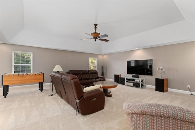 living room with light colored carpet, a tray ceiling, and ceiling fan