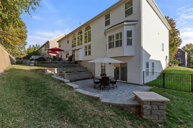 back of house with a yard and a patio