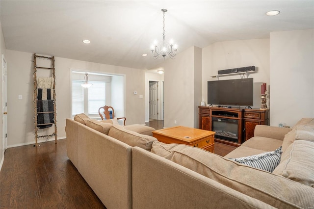 living room with lofted ceiling, a notable chandelier, and dark hardwood / wood-style flooring