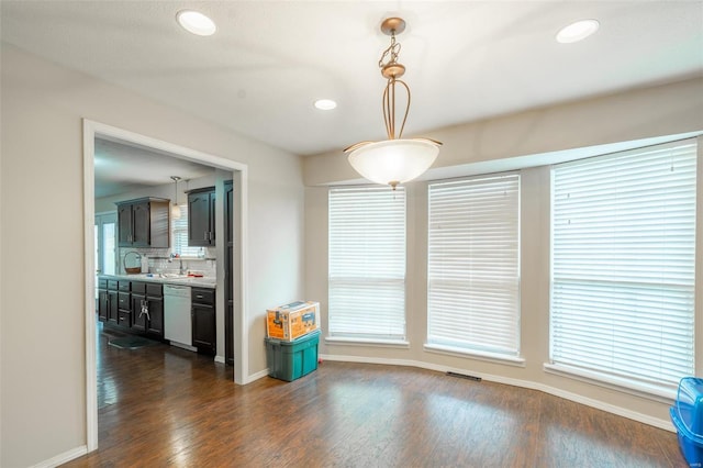 unfurnished dining area featuring sink and dark hardwood / wood-style flooring