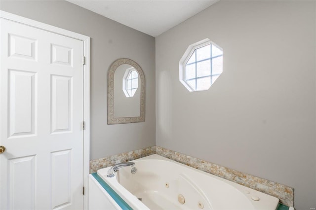 bathroom with a tub to relax in and a textured ceiling