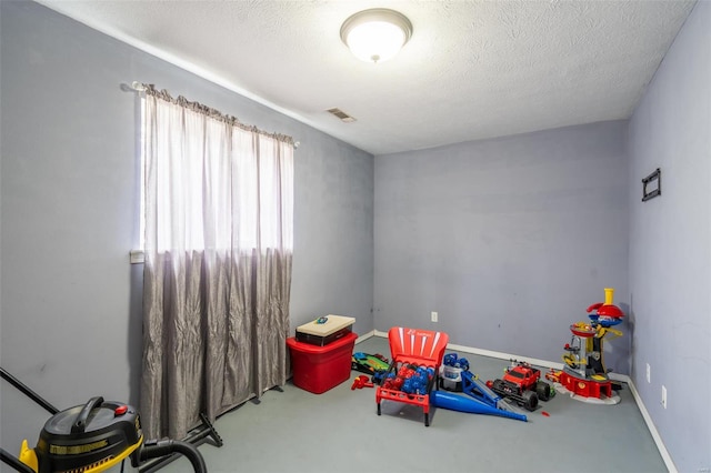 recreation room featuring a textured ceiling