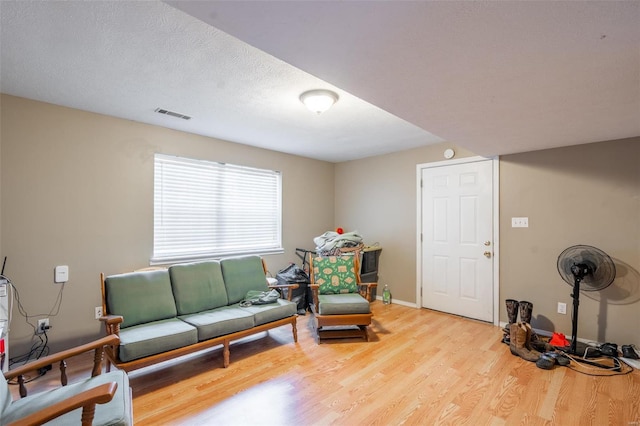 living area featuring wood-type flooring and a textured ceiling