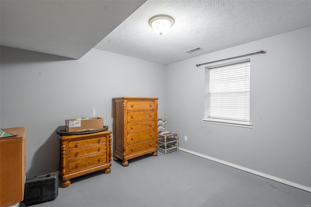 bedroom featuring concrete floors and a textured ceiling