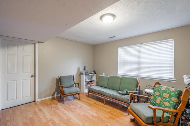 living area featuring a textured ceiling and light wood-type flooring