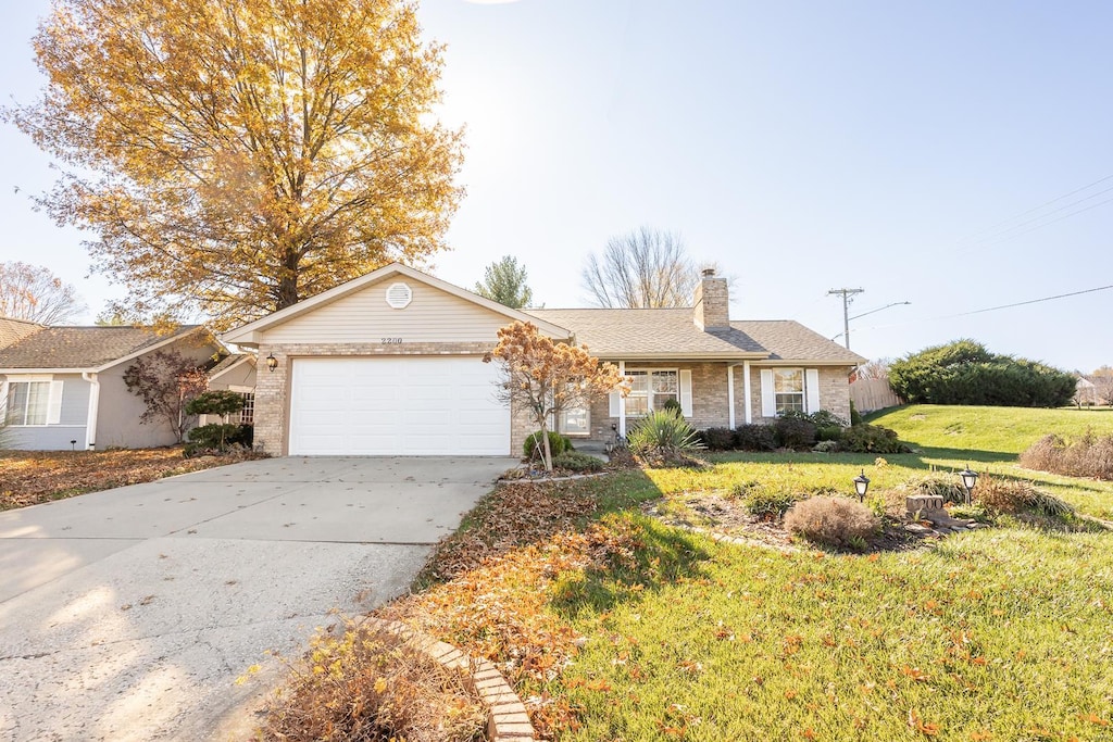 ranch-style home featuring a garage and a front lawn