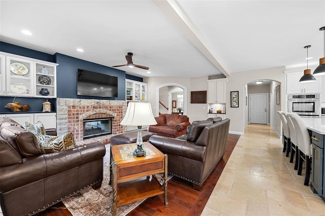 living room with a fireplace and ceiling fan