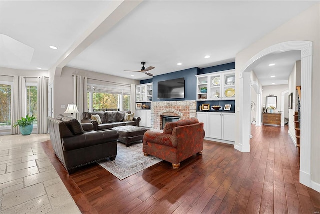 living room with dark hardwood / wood-style floors, a fireplace, and ceiling fan