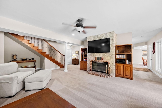 living room featuring a fireplace, light colored carpet, and ceiling fan