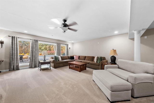 living room with ornate columns, ceiling fan, and light carpet