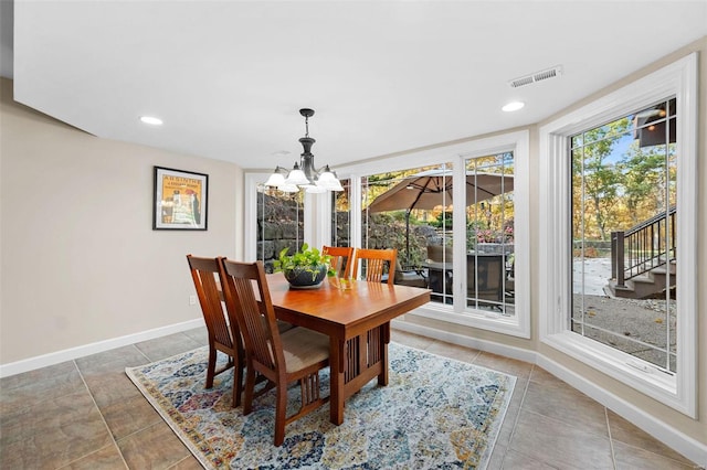 tiled dining area featuring an inviting chandelier and a healthy amount of sunlight