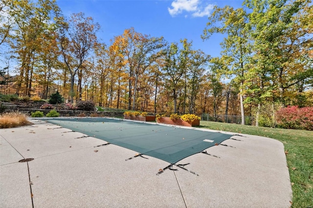 view of pool with a patio and a lawn