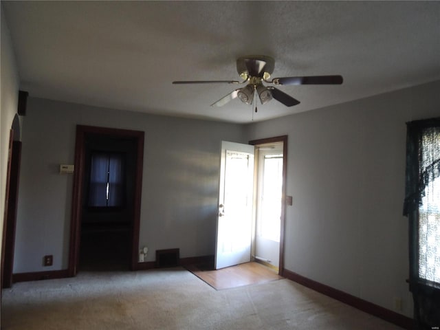 carpeted spare room featuring ceiling fan