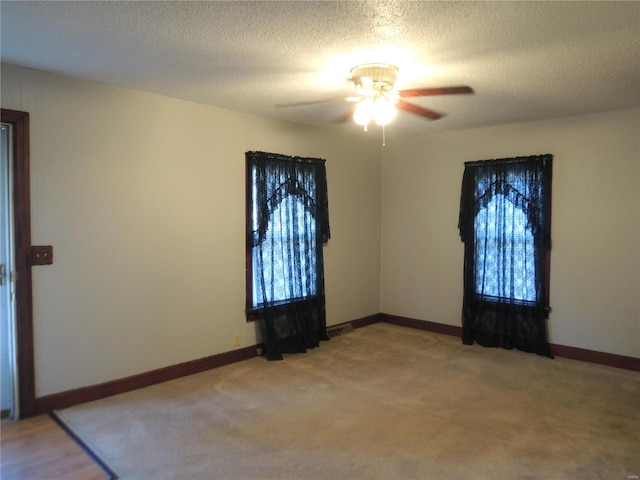 carpeted spare room featuring ceiling fan and a textured ceiling