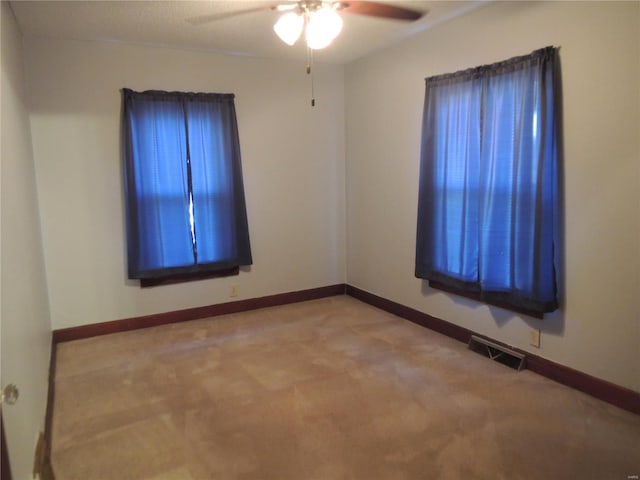 carpeted empty room featuring ceiling fan