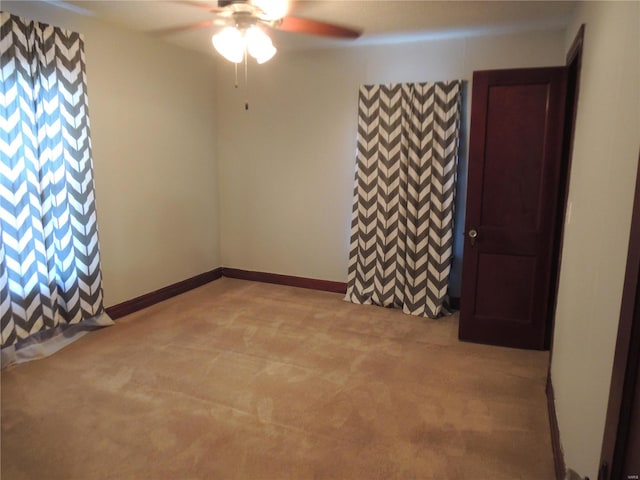 carpeted spare room featuring ceiling fan