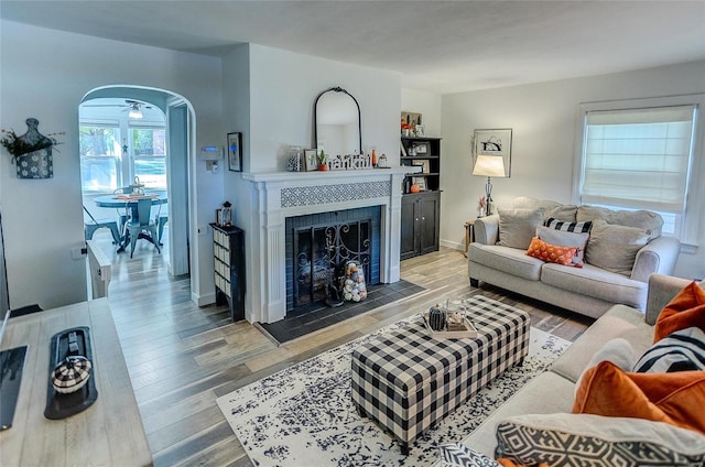 living room with a tiled fireplace and hardwood / wood-style flooring