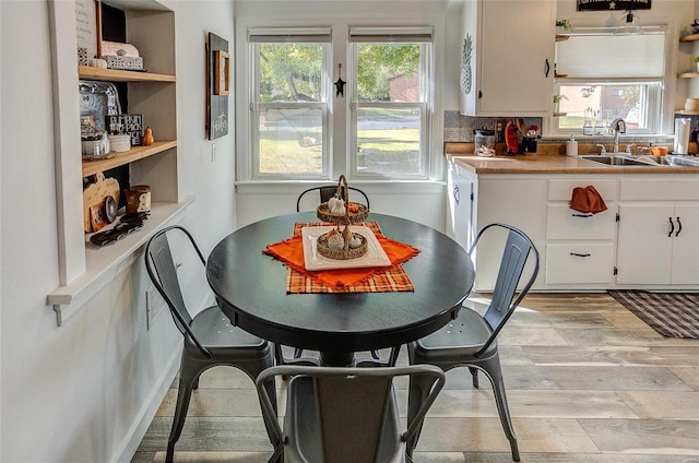 dining room with sink, plenty of natural light, and light wood-type flooring