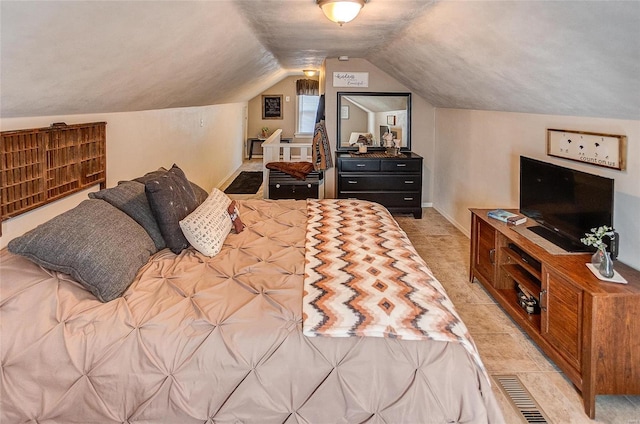 bedroom featuring light tile patterned flooring and vaulted ceiling