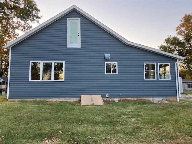 property exterior at dusk featuring a yard