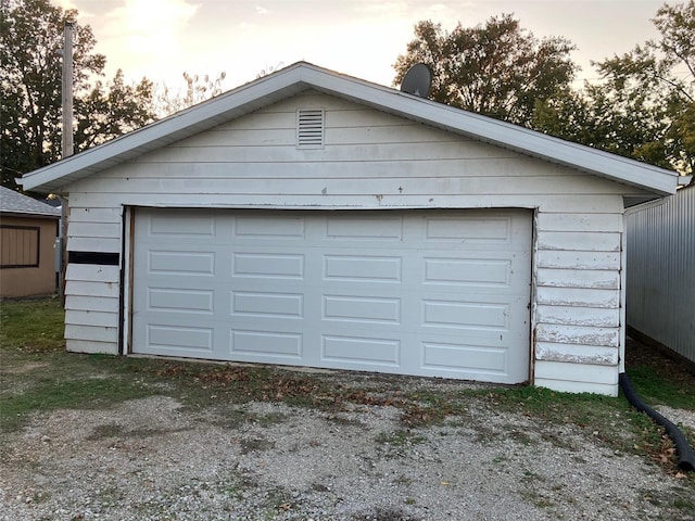 view of garage at dusk