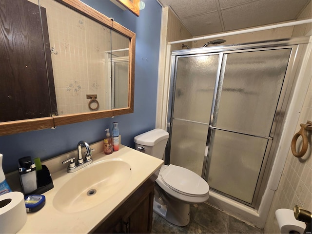 bathroom with tile patterned flooring, vanity, toilet, and a shower with shower door