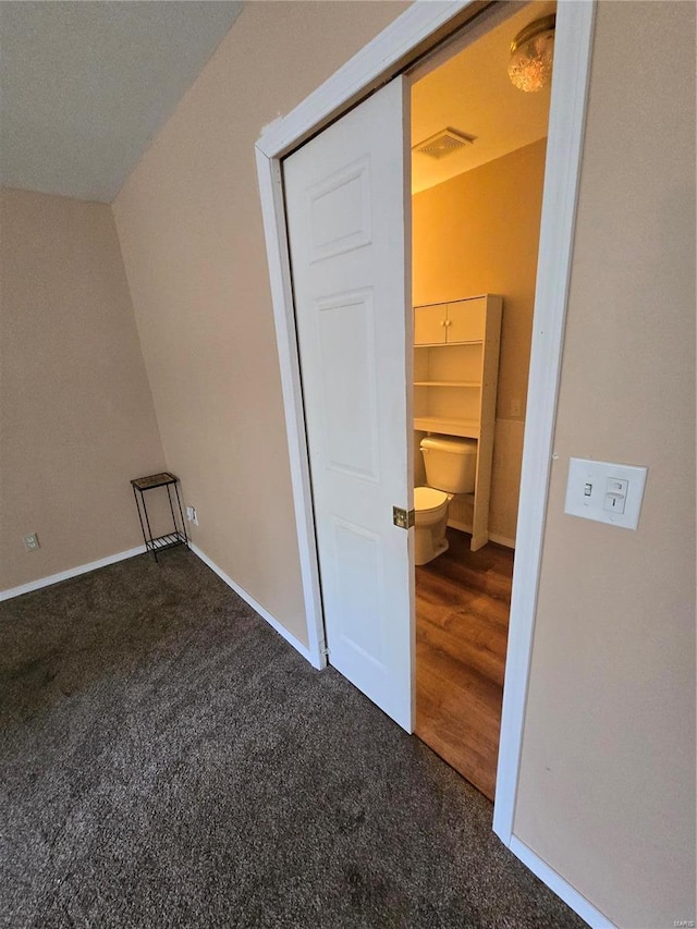 bonus room featuring vaulted ceiling and dark colored carpet