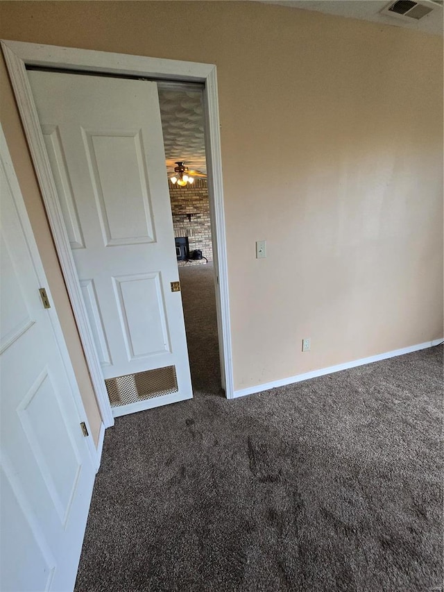 unfurnished bedroom featuring a closet, a fireplace, and carpet