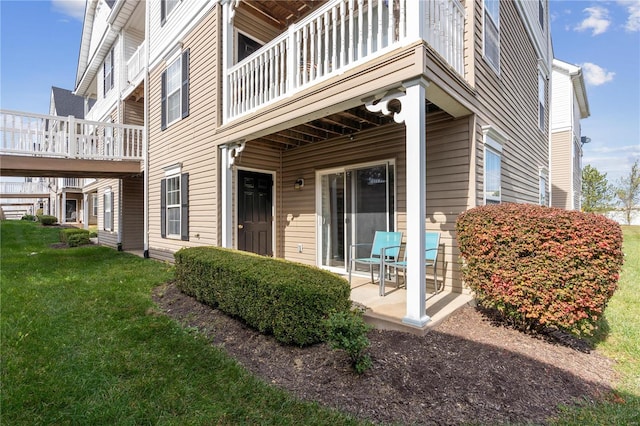 entrance to property with a yard and a patio area