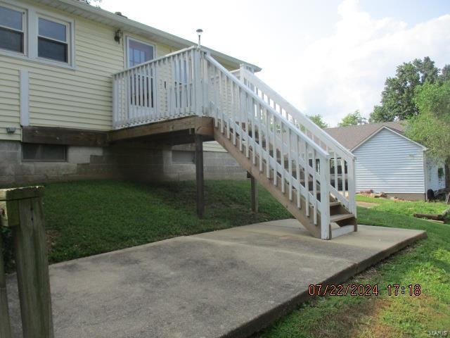 rear view of house with a yard and a deck