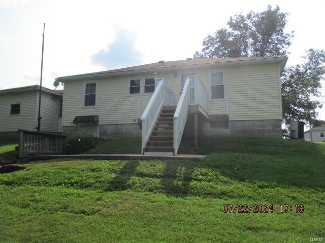 rear view of property with a lawn