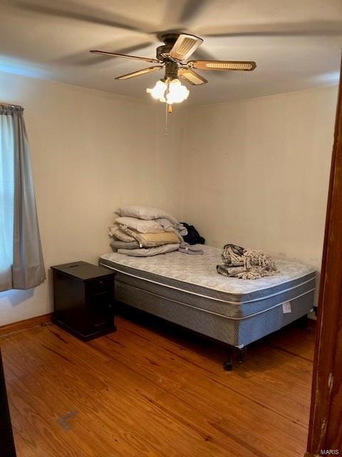 unfurnished bedroom featuring wood-type flooring and ceiling fan