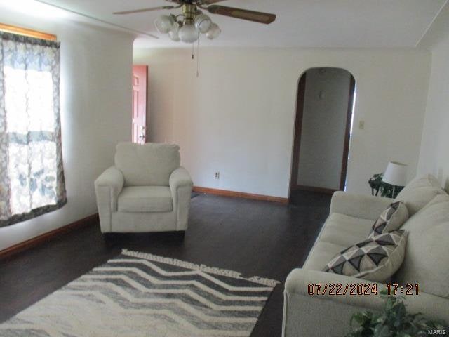 living room featuring ceiling fan, a healthy amount of sunlight, and dark hardwood / wood-style flooring