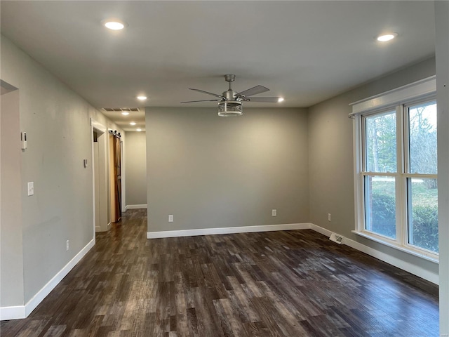 spare room with ceiling fan and dark wood-type flooring