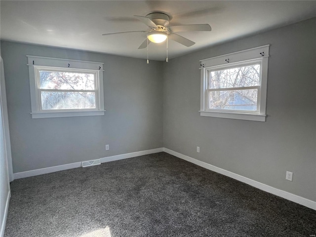 carpeted spare room with plenty of natural light and ceiling fan