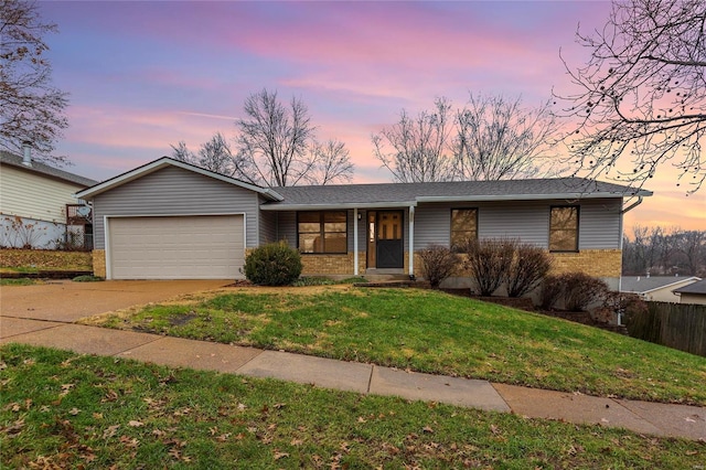 ranch-style home with a garage and a yard