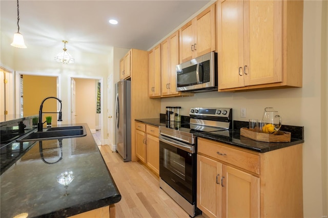 kitchen with hanging light fixtures, light brown cabinets, sink, and appliances with stainless steel finishes