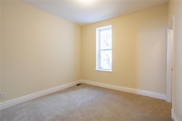 spare room featuring light colored carpet