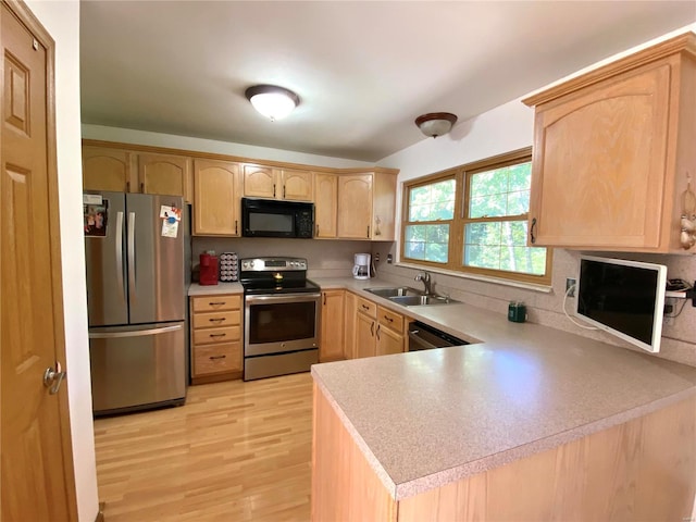 kitchen featuring kitchen peninsula, appliances with stainless steel finishes, sink, and light brown cabinets