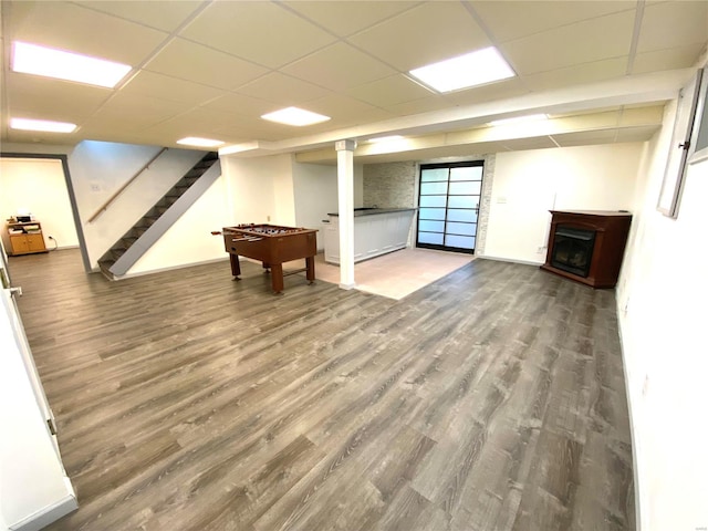 basement with a paneled ceiling and hardwood / wood-style flooring