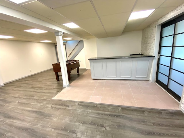 basement with pool table, a paneled ceiling, and light hardwood / wood-style floors