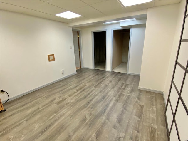 unfurnished room featuring a paneled ceiling and light hardwood / wood-style flooring