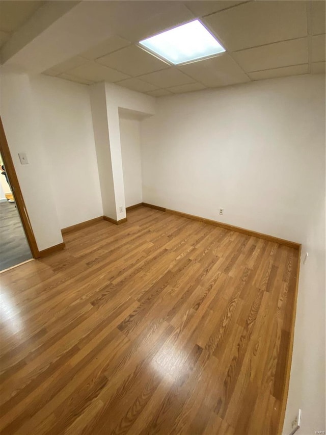 basement with hardwood / wood-style floors and a drop ceiling