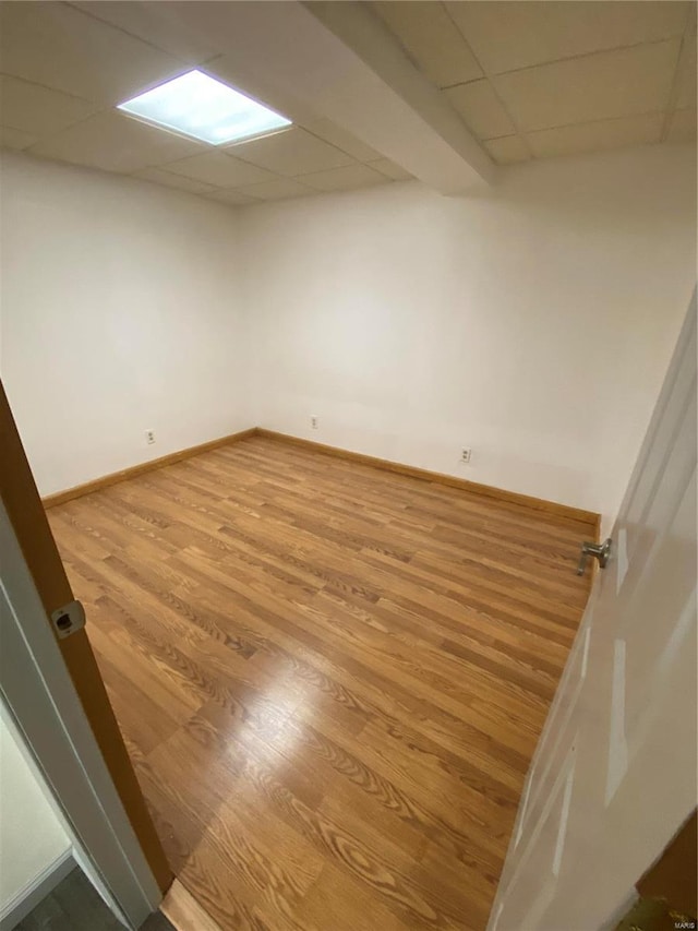 spare room featuring hardwood / wood-style floors and a paneled ceiling