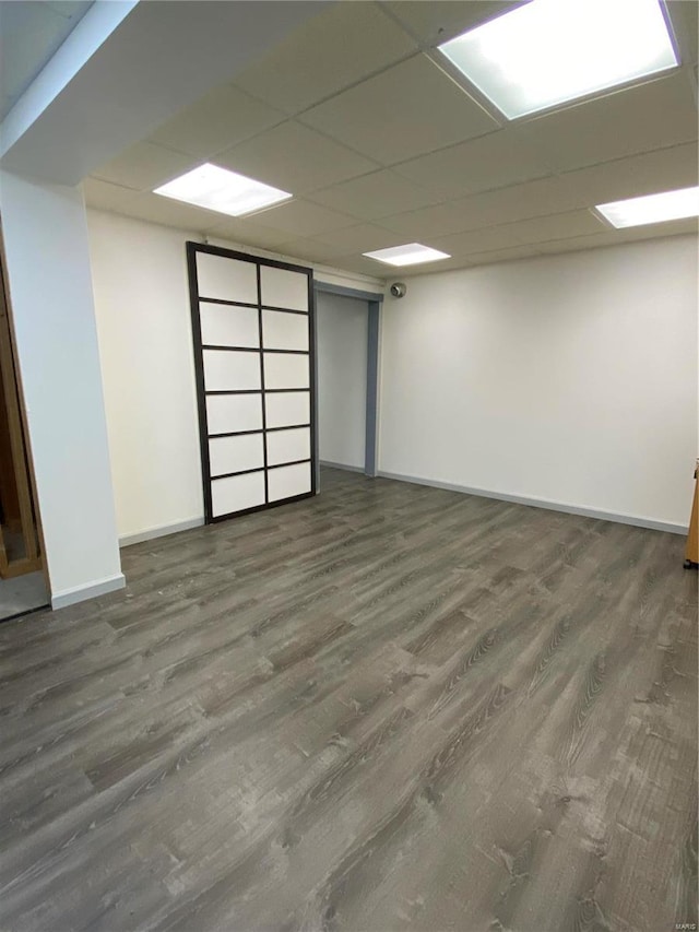 basement featuring dark hardwood / wood-style flooring and a drop ceiling