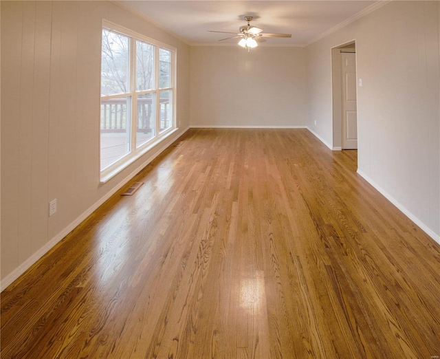 spare room with crown molding, ceiling fan, and light wood-type flooring